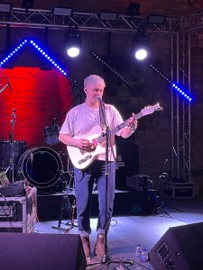 Soft Lad (Sophie Galpin) playing guitar and singing songs at Gloucester Underground Festival 2024
