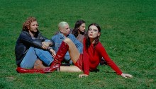 Wolf Alice band members sitting in a field