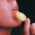 A woman taking a bite out of a lemon